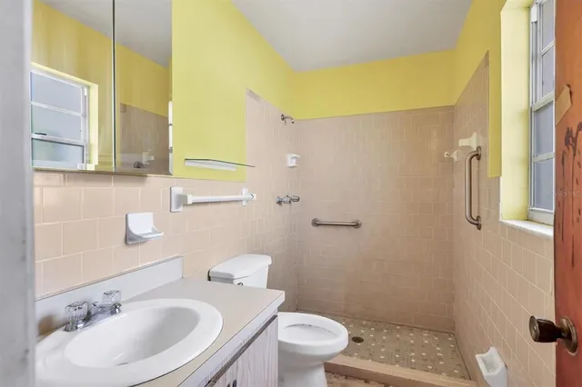 a bathroom with a sink toilet a mirror and shower