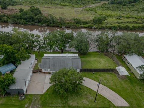 483 Riverside Drive Palacios, TX 77465 - Photo 5 of 41 an aerial view of a house with a yard and lake view