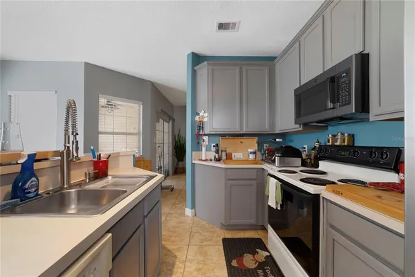 a kitchen with stainless steel appliances granite countertop a sink stove and microwave