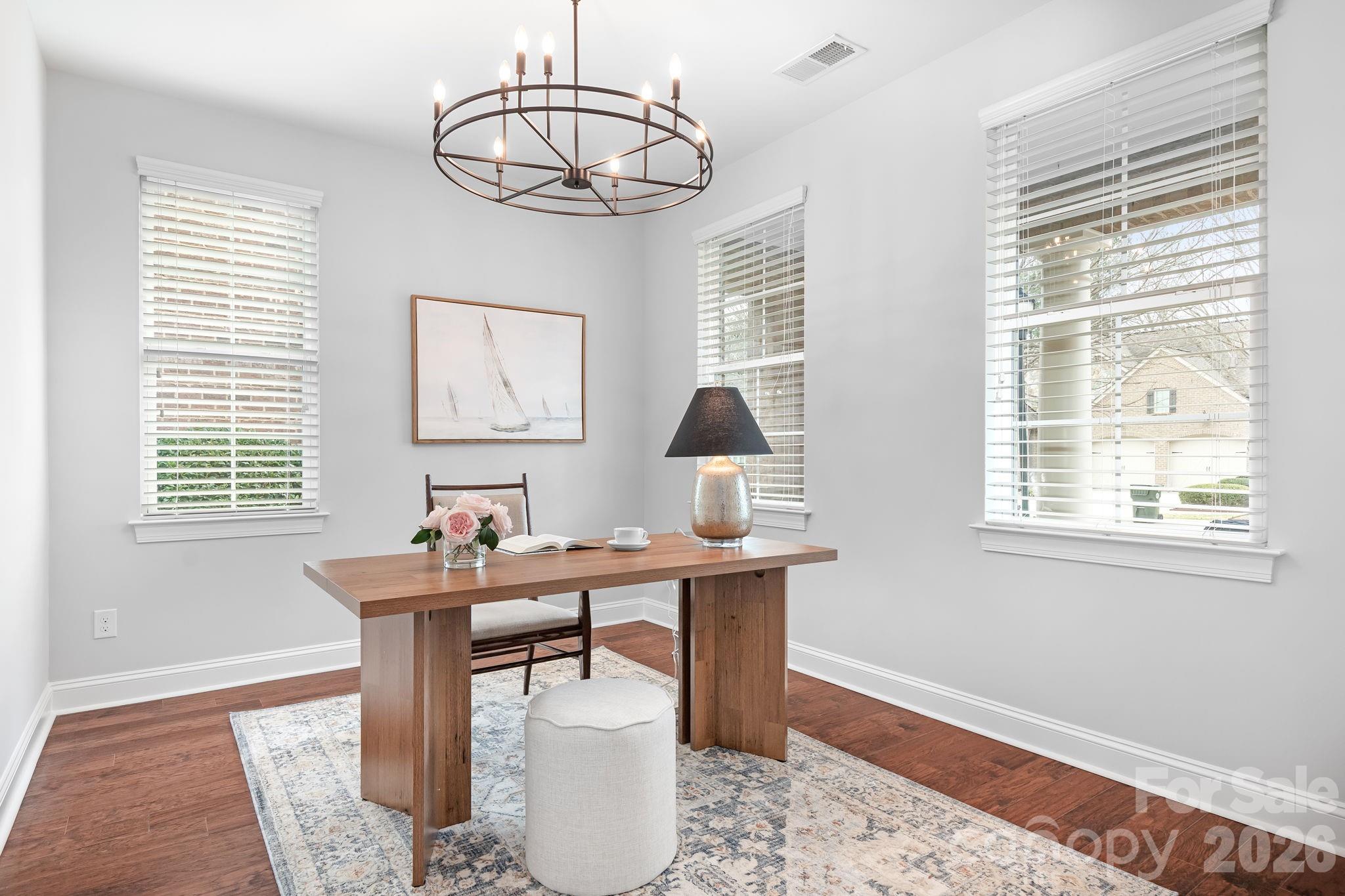 9121 Robbins Preserve Road Cornelius, NC 28031 - Photo 6 of 47 a dining room with wooden floor a chandelier a wooden table and chairs