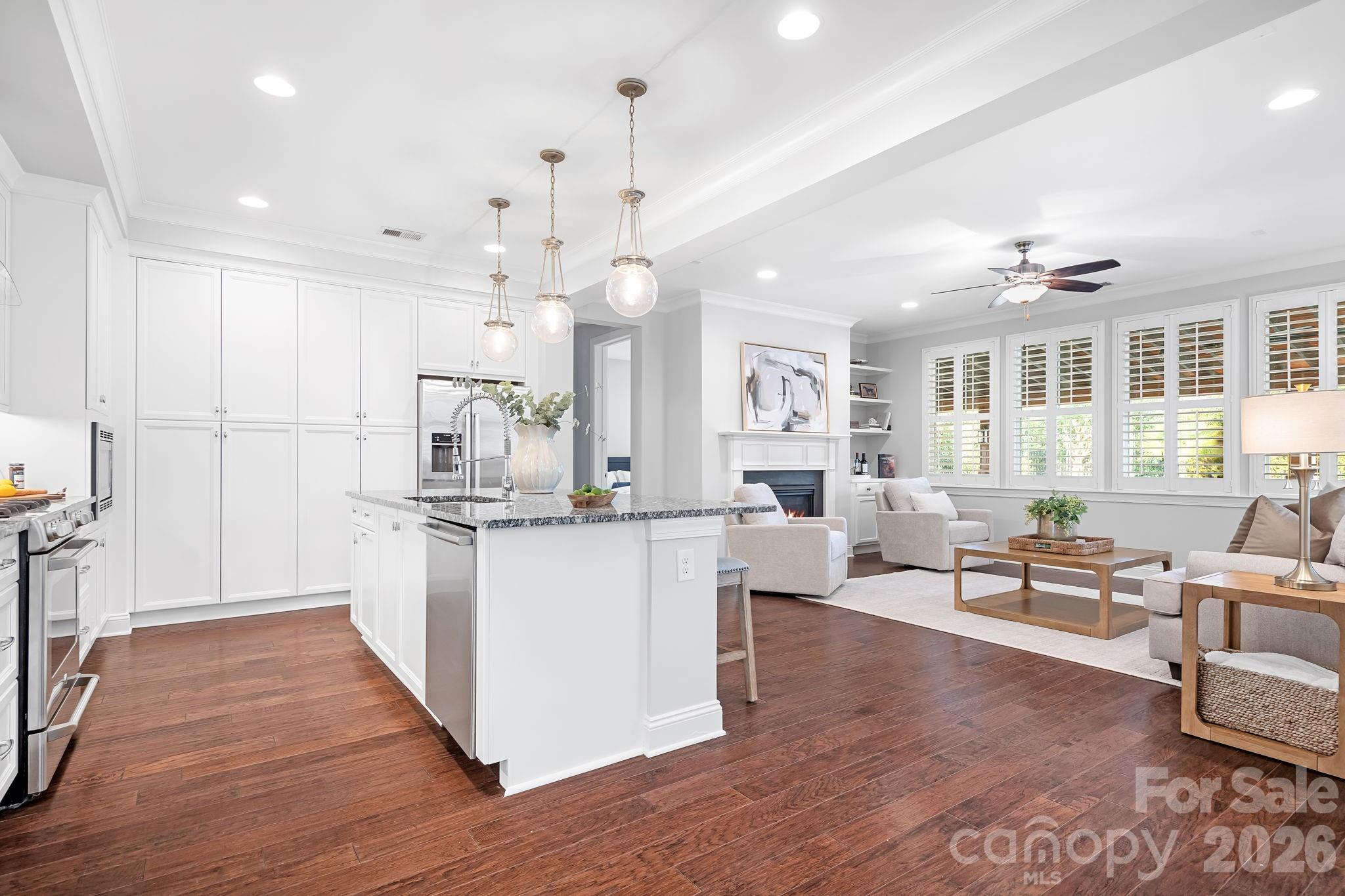9121 Robbins Preserve Road Cornelius, NC 28031 - Photo 8 of 47 a open kitchen with kitchen island a refrigerator a stove a sink dishwasher and a dining table with wooden floor