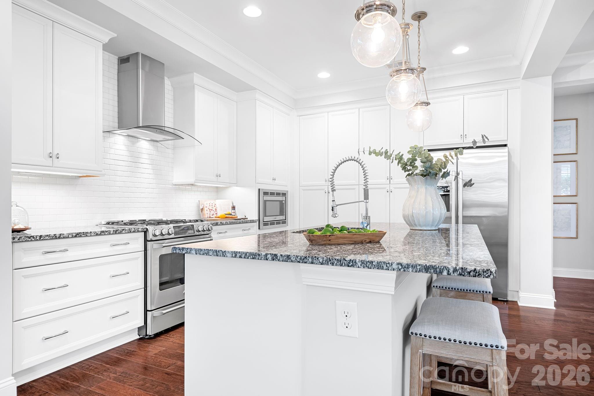 9121 Robbins Preserve Road Cornelius, NC 28031 - Photo 9 of 47 a kitchen with stainless steel appliances granite countertop a stove and white cabinets