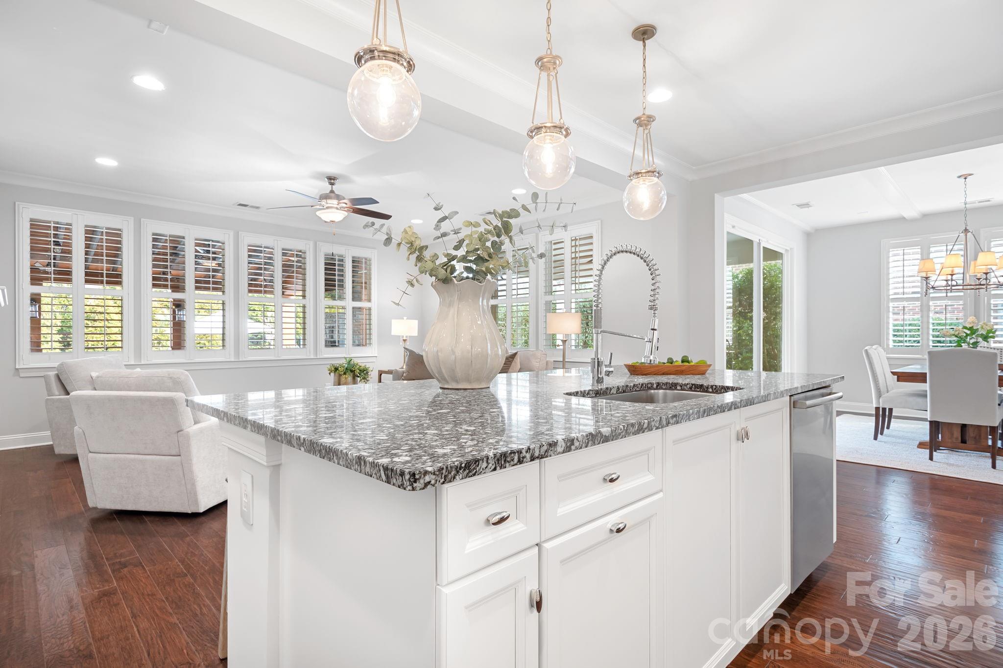 9121 Robbins Preserve Road Cornelius, NC 28031 - Photo 10 of 47 an open kitchen with granite countertop a stove a sink a dining table and chairs with wooden floor