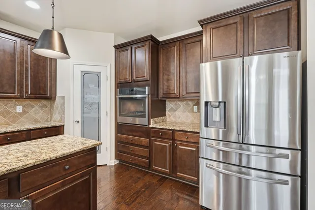 a kitchen with stainless steel appliances granite countertop a refrigerator and a stove top oven