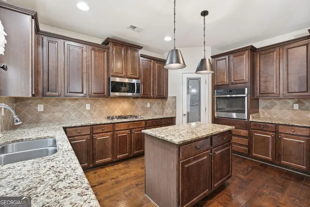 a kitchen with stainless steel appliances granite countertop a sink stove and refrigerator
