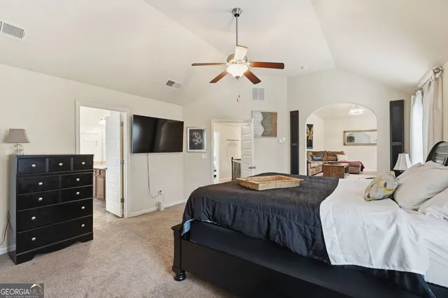 a bedroom with a bed a window and a flat screen television