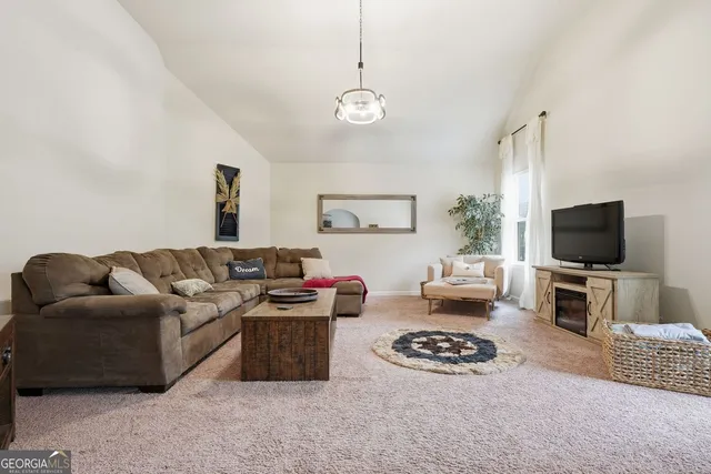 a living room with furniture a flat screen tv and a window