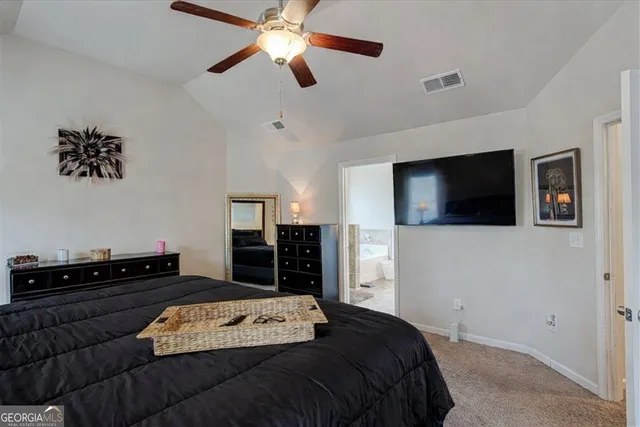 a bedroom with a bed and a flat tv screen on the dresser