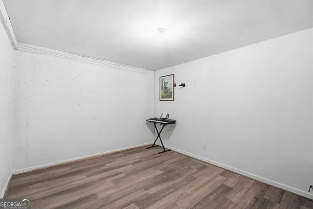 a view of a room with wooden floor and a window