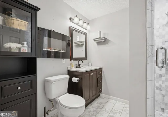 a bathroom with a toilet a sink and mirror