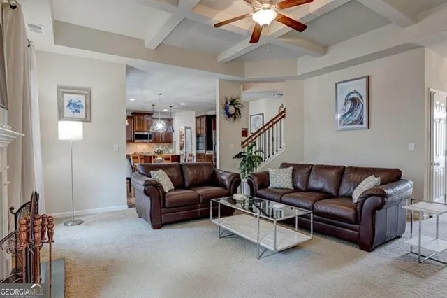a living room with furniture kitchen view and a chandelier