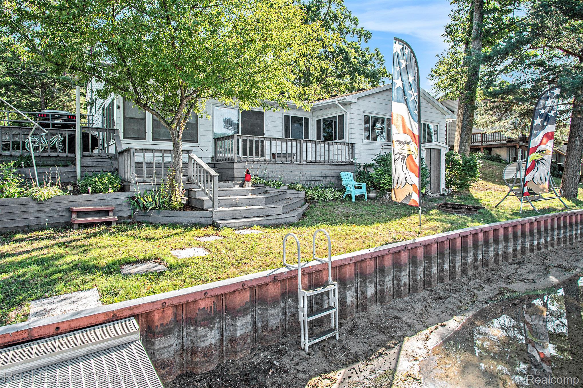 1734 Forest Road Harrison, MI 48625 - Photo 23 of 31 Back of property featuring a deck and a lawn