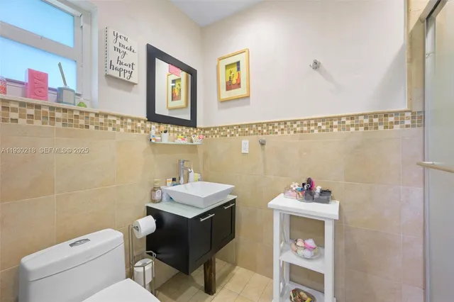 a bathroom with a toilet sink and mirror