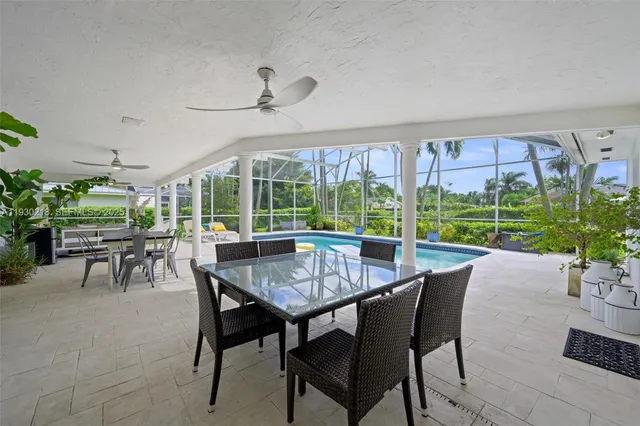 a dining room with furniture a rug and a floor to ceiling window