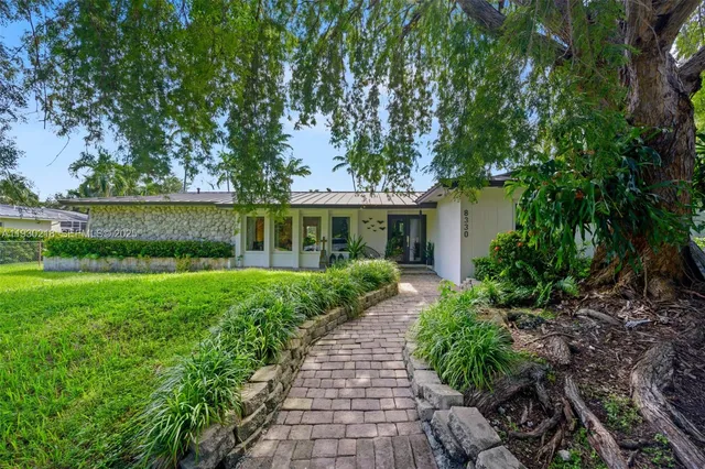 a front view of a house with a yard and potted plants