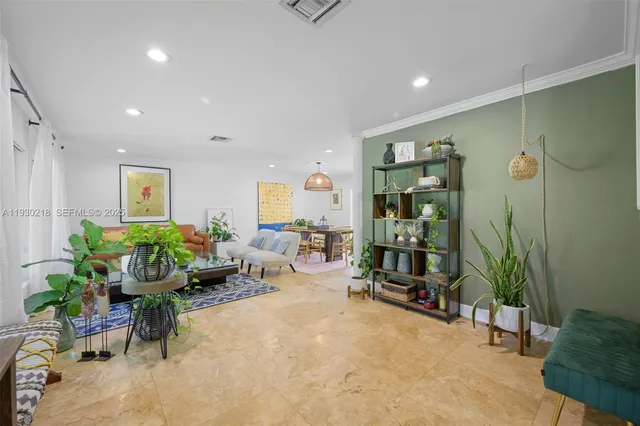 a living room with furniture and potted plants