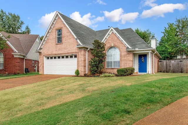 a view of a house with a yard and garage