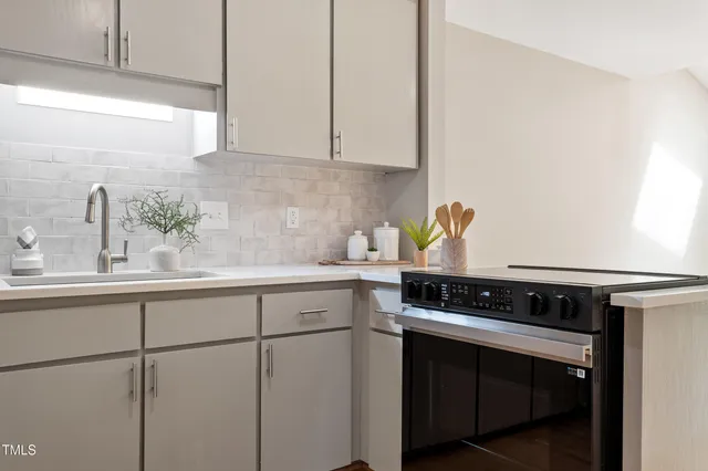 a kitchen with stainless steel appliances a sink stove and cabinets