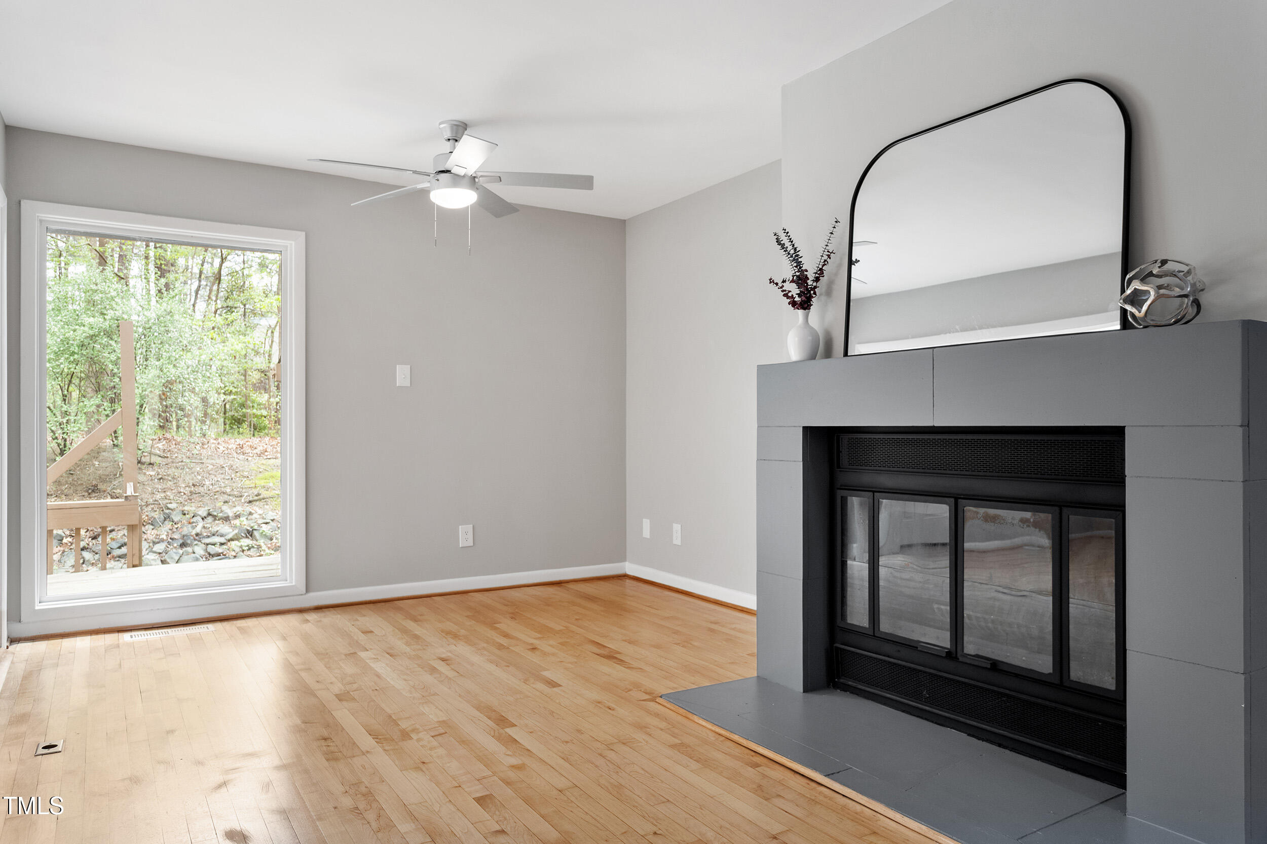 58 Stoneridge Road Durham, NC 27705 - Photo 15 of 38 a view of an empty room with wooden floor fireplace and a window