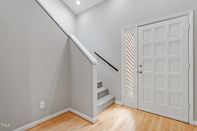 a view of an empty room with wooden floor and entryway