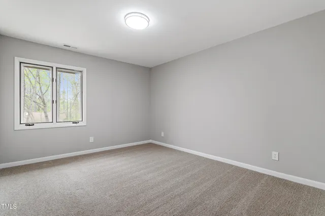 an empty room with closet and windows