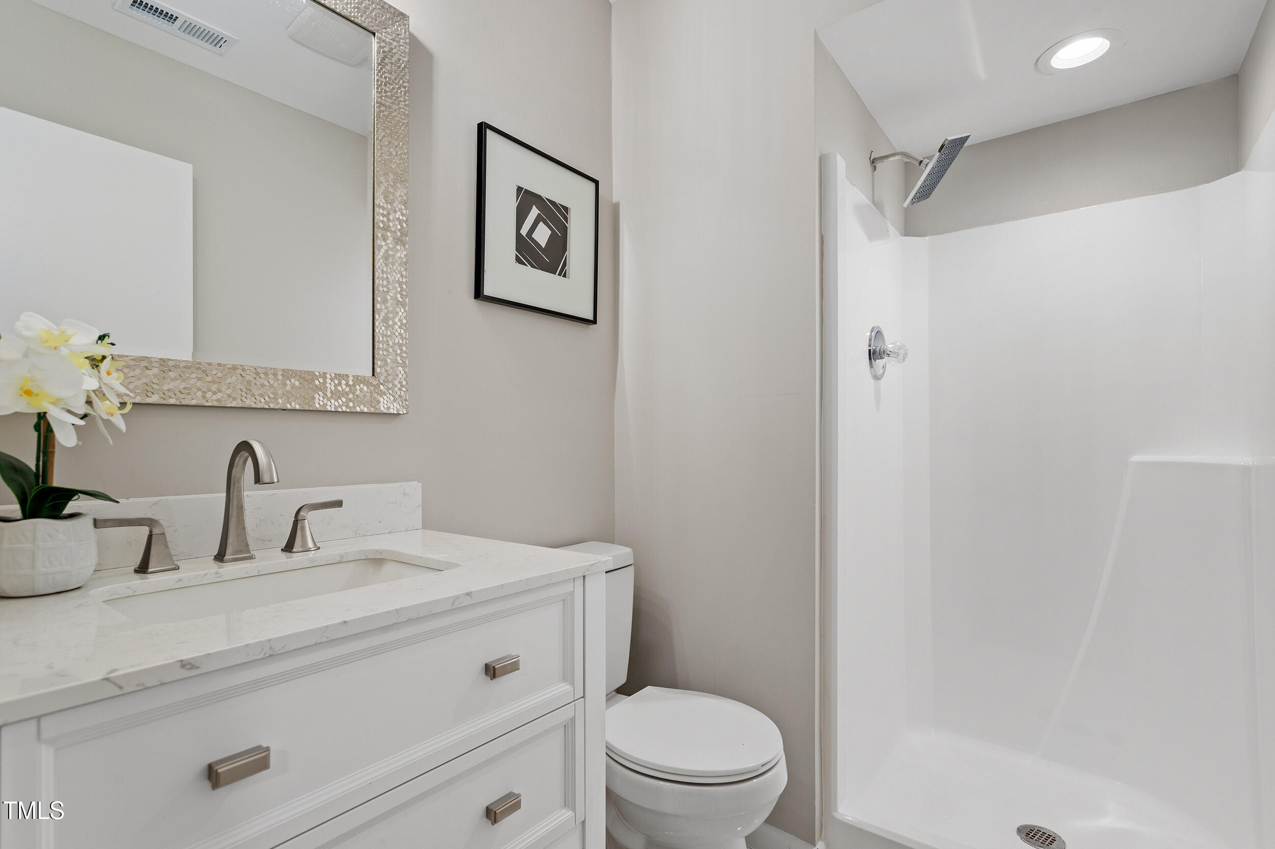 58 Stoneridge Road Durham, NC 27705 - Photo 8 of 38 a bathroom with a toilet a sink a mirror a vanity and shower