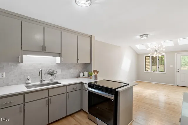 a kitchen with stainless steel appliances granite countertop a sink stove and cabinets