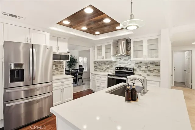 a kitchen with stainless steel appliances kitchen island granite countertop a refrigerator stove and sink