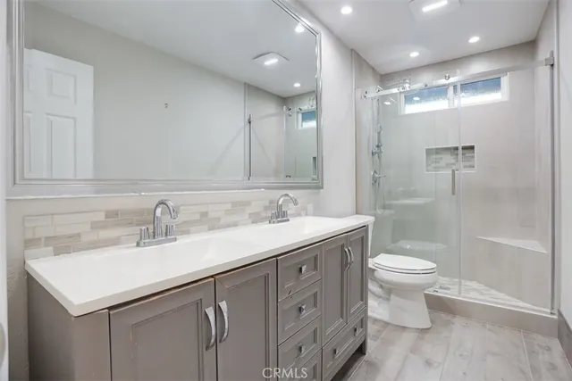 a bathroom with a sink a toilet and shower