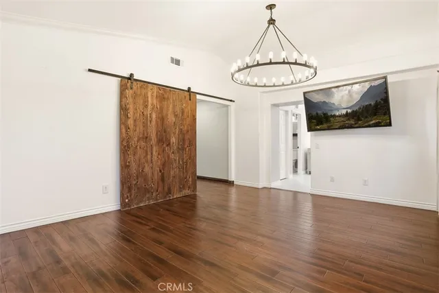 a view of a room with wooden floor and flat screen tv