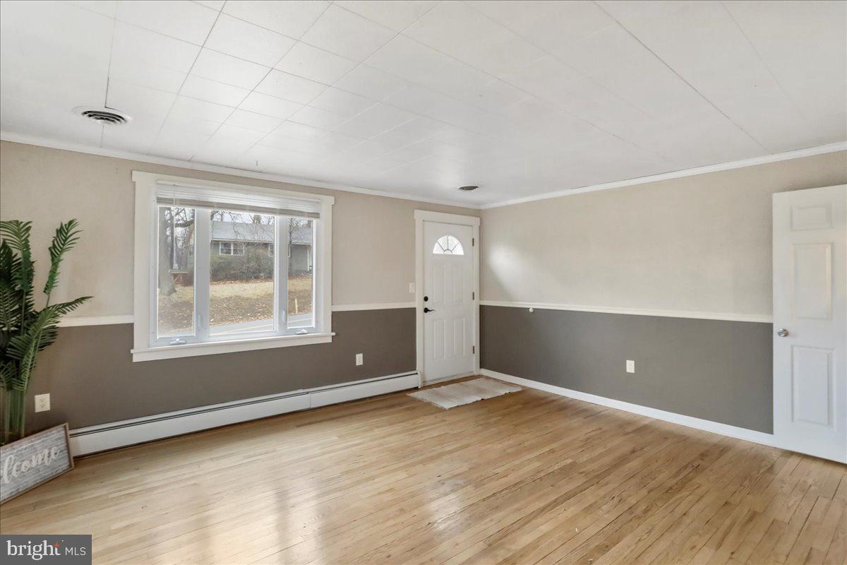 13815 Brant Road Southwest Cresaptown, MD 21502 - Photo 5 of 40 a view of an empty room with wooden floor and a window