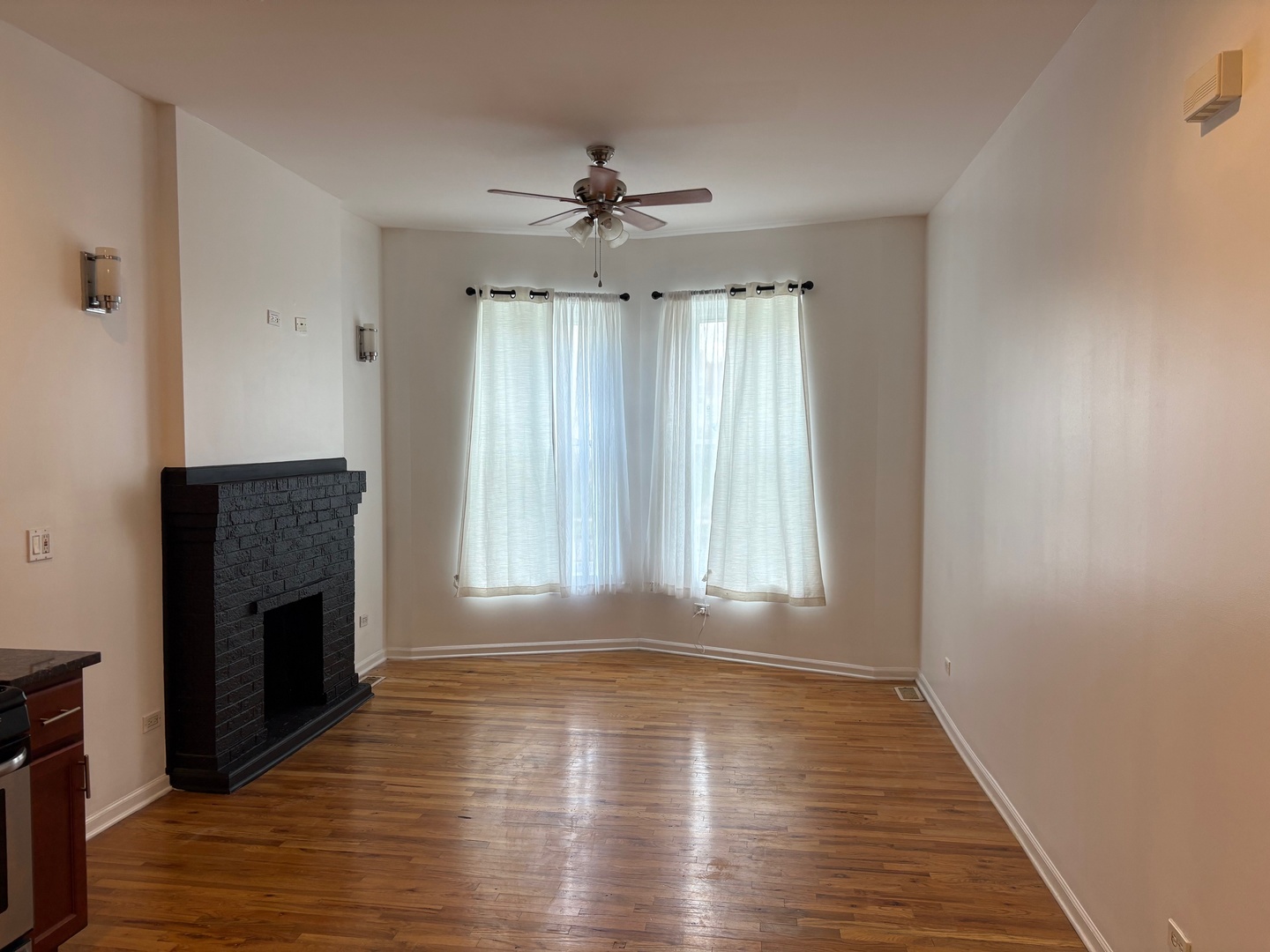 524 West 78th Street, Unit 1 Chicago, IL 60620 - Photo 2 of 9 an empty room with wooden floor fireplace and windows