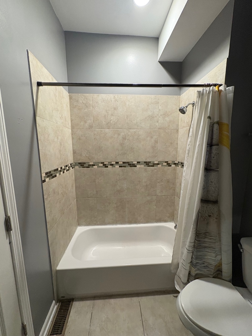 524 West 78th Street, Unit 1 Chicago, IL 60620 - Photo 6 of 9 a bathroom with a bathtub and a shower