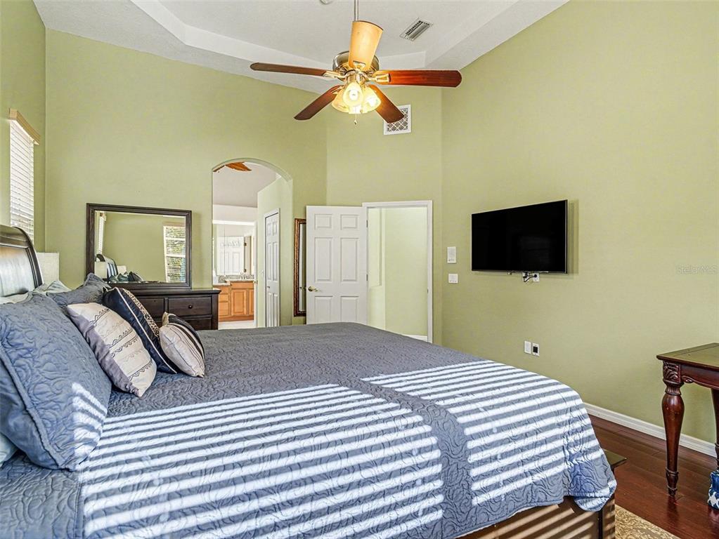 8443 Sailing Loop Lakewood Ranch, FL 34202 - Photo 21 of 34 a bedroom with a bed and a flat screen tv
