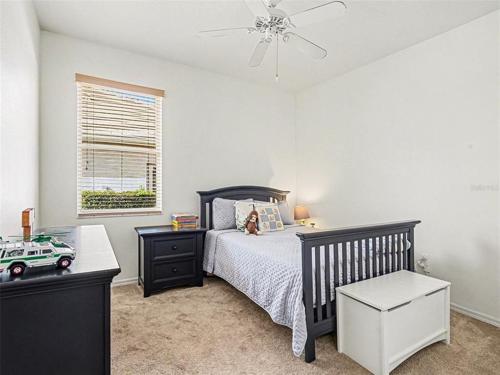 8443 Sailing Loop Lakewood Ranch, FL 34202 - Photo 25 of 34 a bedroom with a bed and a chandelier