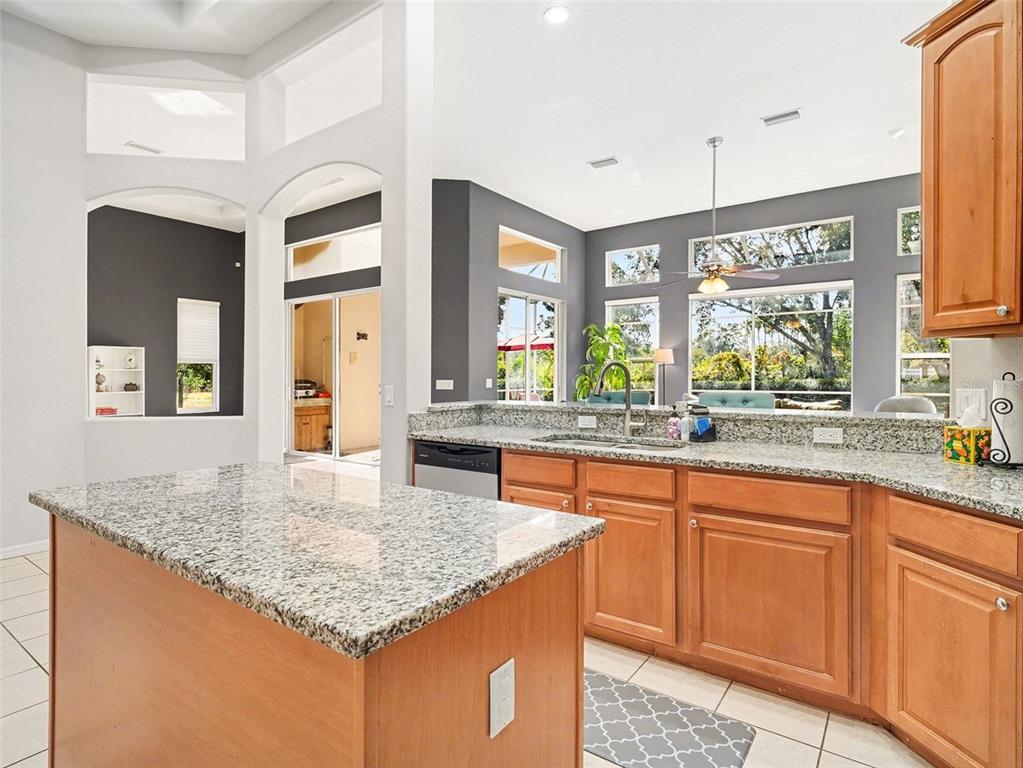 8443 Sailing Loop Lakewood Ranch, FL 34202 - Photo 4 of 34 a kitchen with granite countertop kitchen island sink and living room view