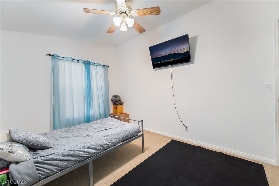 1551 West Wilson Road Pahrump, NV 89048 - Photo 35 of 68 Plentiful natural light fills this cozy bedroom featuring soft carpeting.