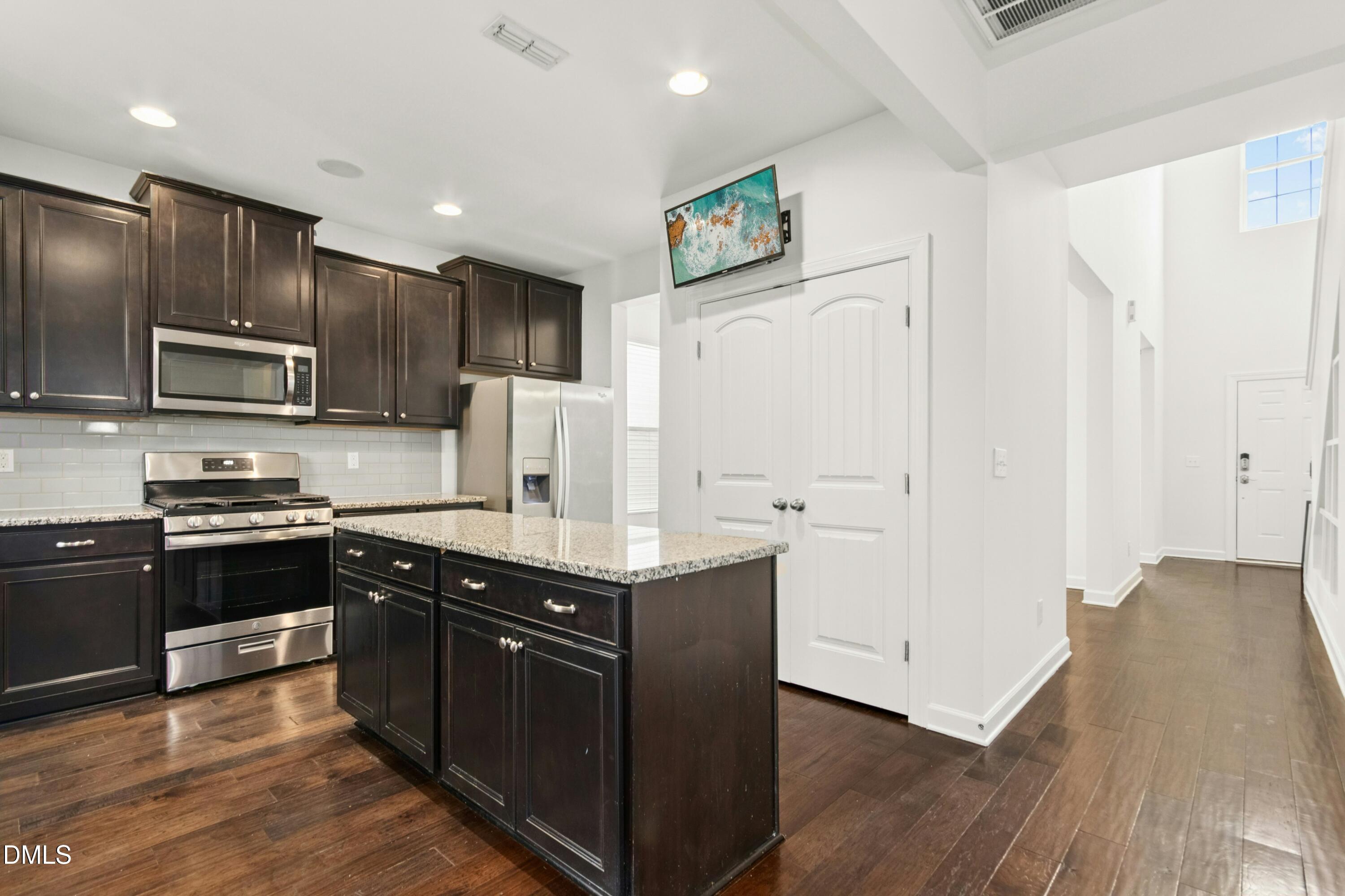 125 Spring Pine Lane Holly Springs, NC 27540 - Photo 9 of 34 a kitchen with stainless steel appliances granite countertop a refrigerator a stove a sink and a microwave