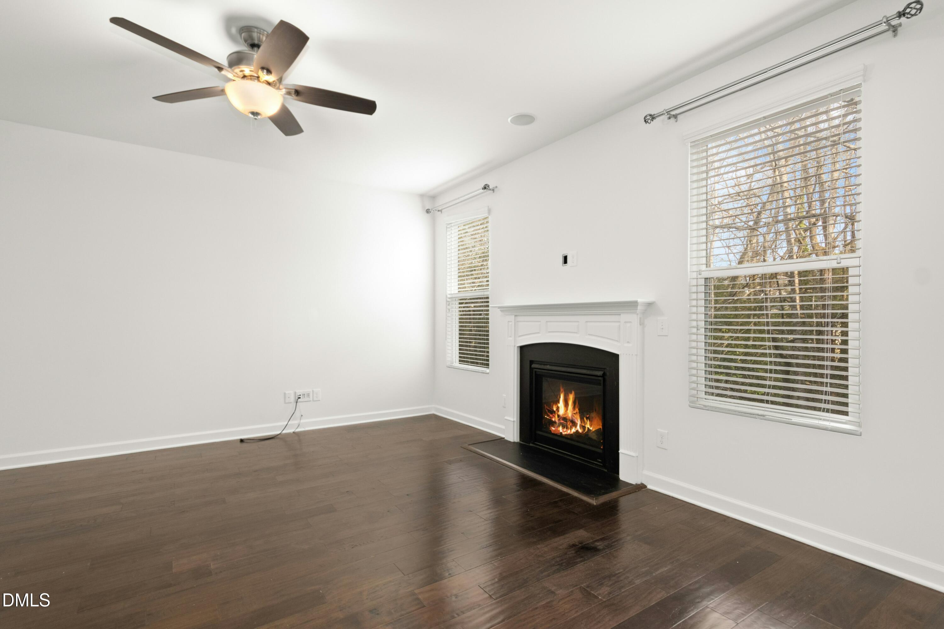 125 Spring Pine Lane Holly Springs, NC 27540 - Photo 13 of 34 wooden floor fireplace and windows in an empty room