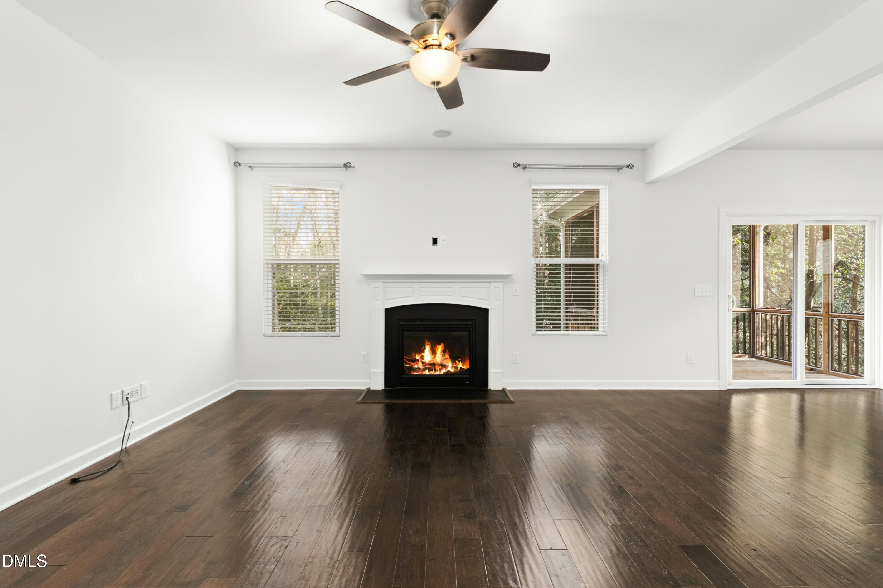 125 Spring Pine Lane Holly Springs, NC 27540 - Photo 14 of 34 a living room with wooden floor a fireplace and a window