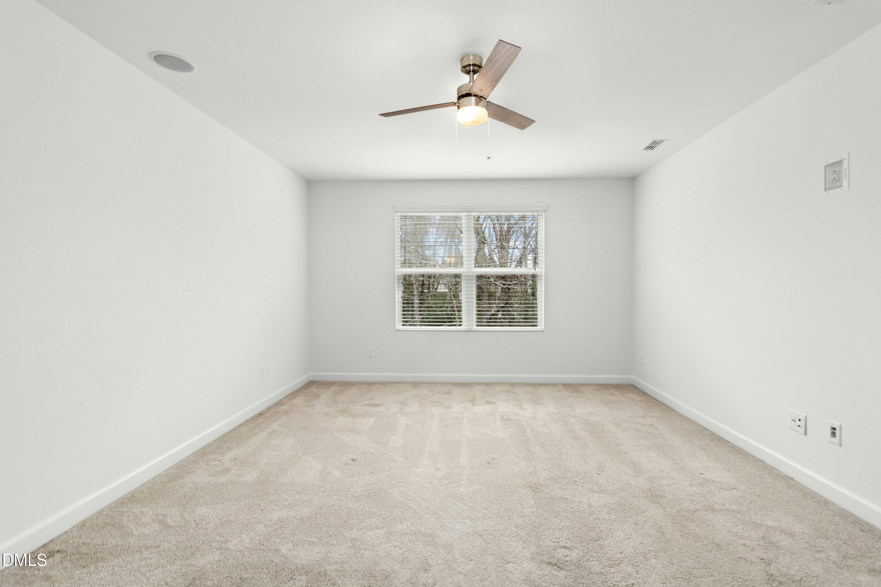 125 Spring Pine Lane Holly Springs, NC 27540 - Photo 17 of 34 an empty room with a window and a ceiling fan