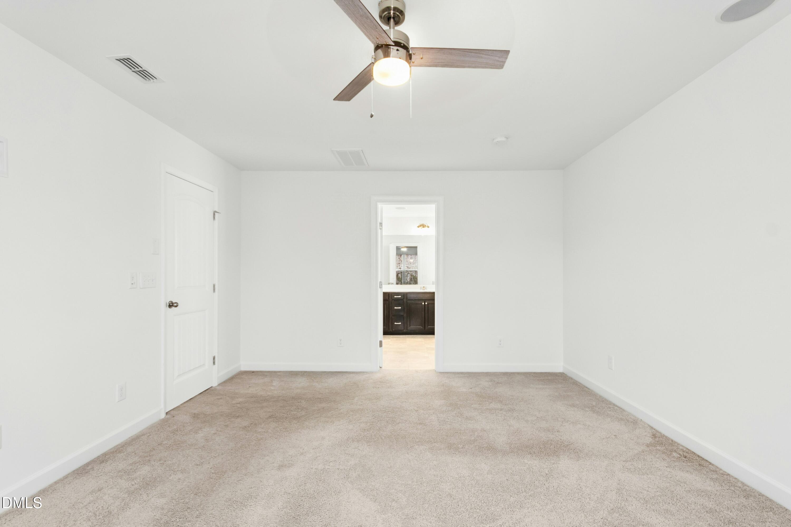 125 Spring Pine Lane Holly Springs, NC 27540 - Photo 18 of 34 an empty room with chandelier fan and windows