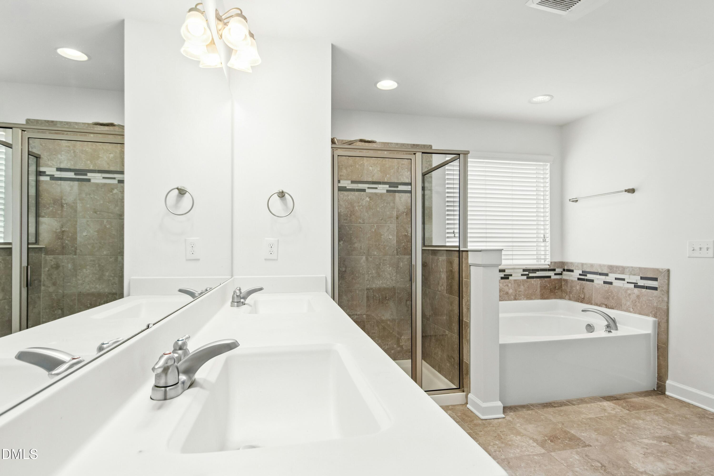 125 Spring Pine Lane Holly Springs, NC 27540 - Photo 21 of 34 a bathroom with a tub sink shower and mirror