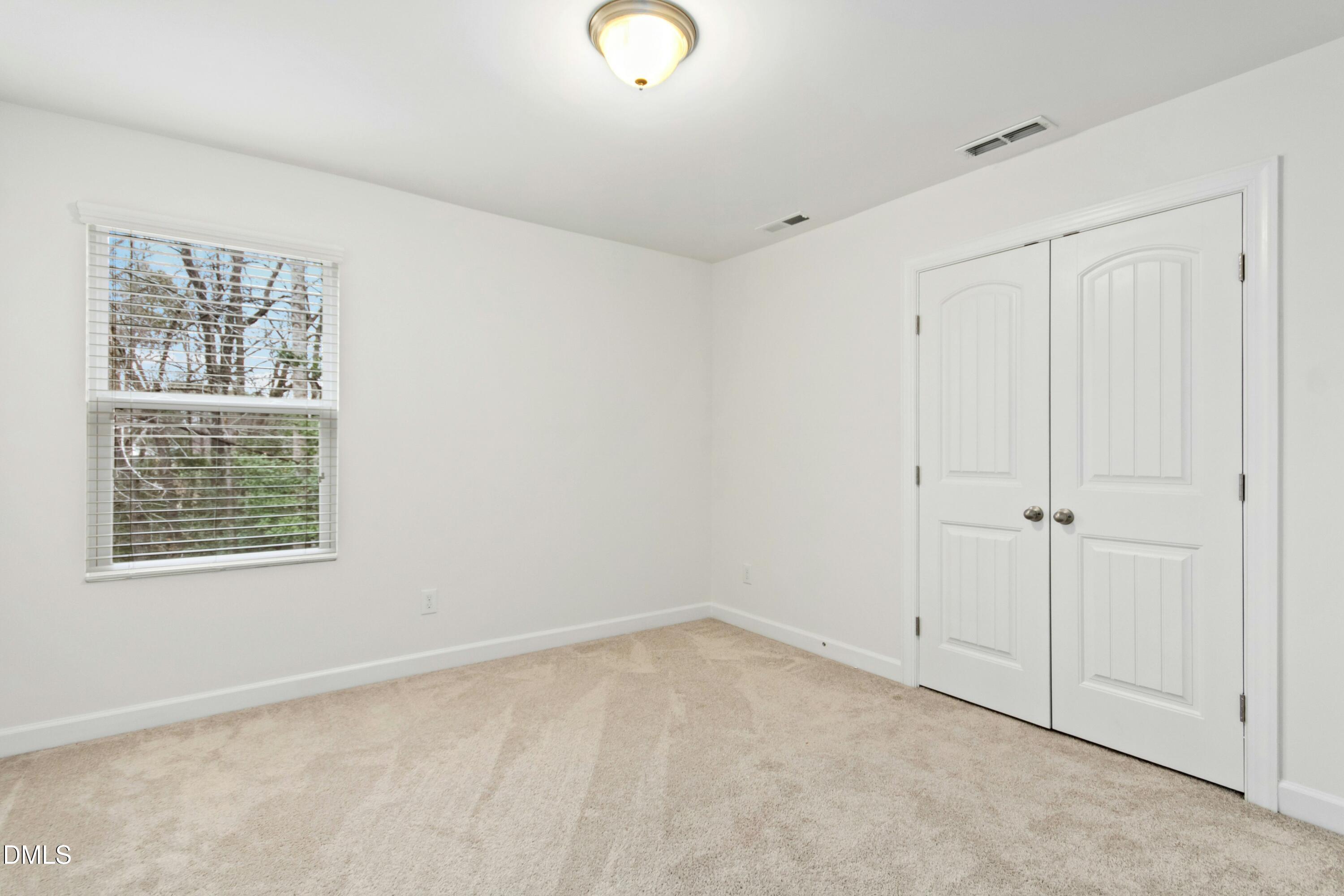 125 Spring Pine Lane Holly Springs, NC 27540 - Photo 23 of 34 a view of an empty room with a window