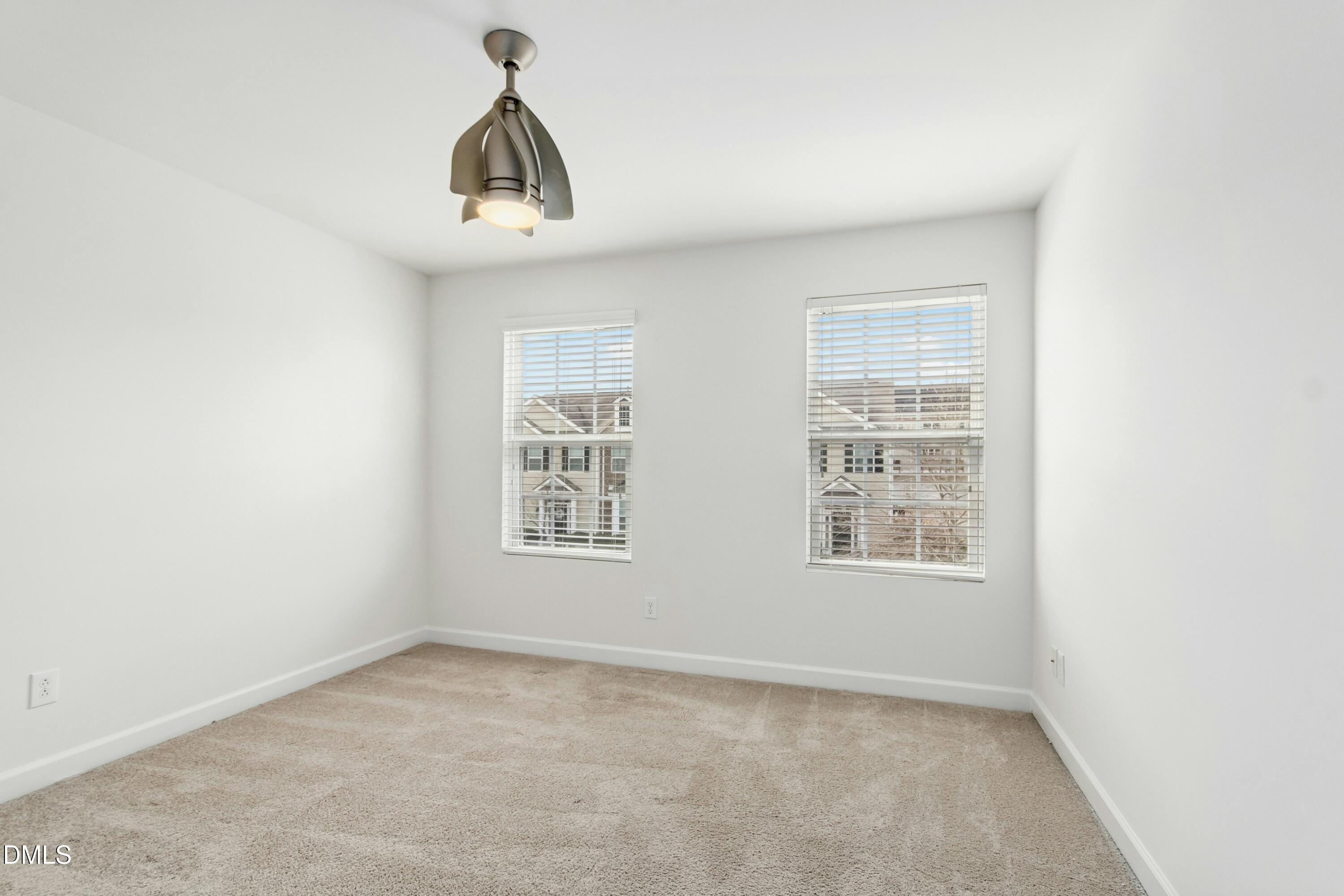 125 Spring Pine Lane Holly Springs, NC 27540 - Photo 25 of 34 an empty room with a window and chandelier fan