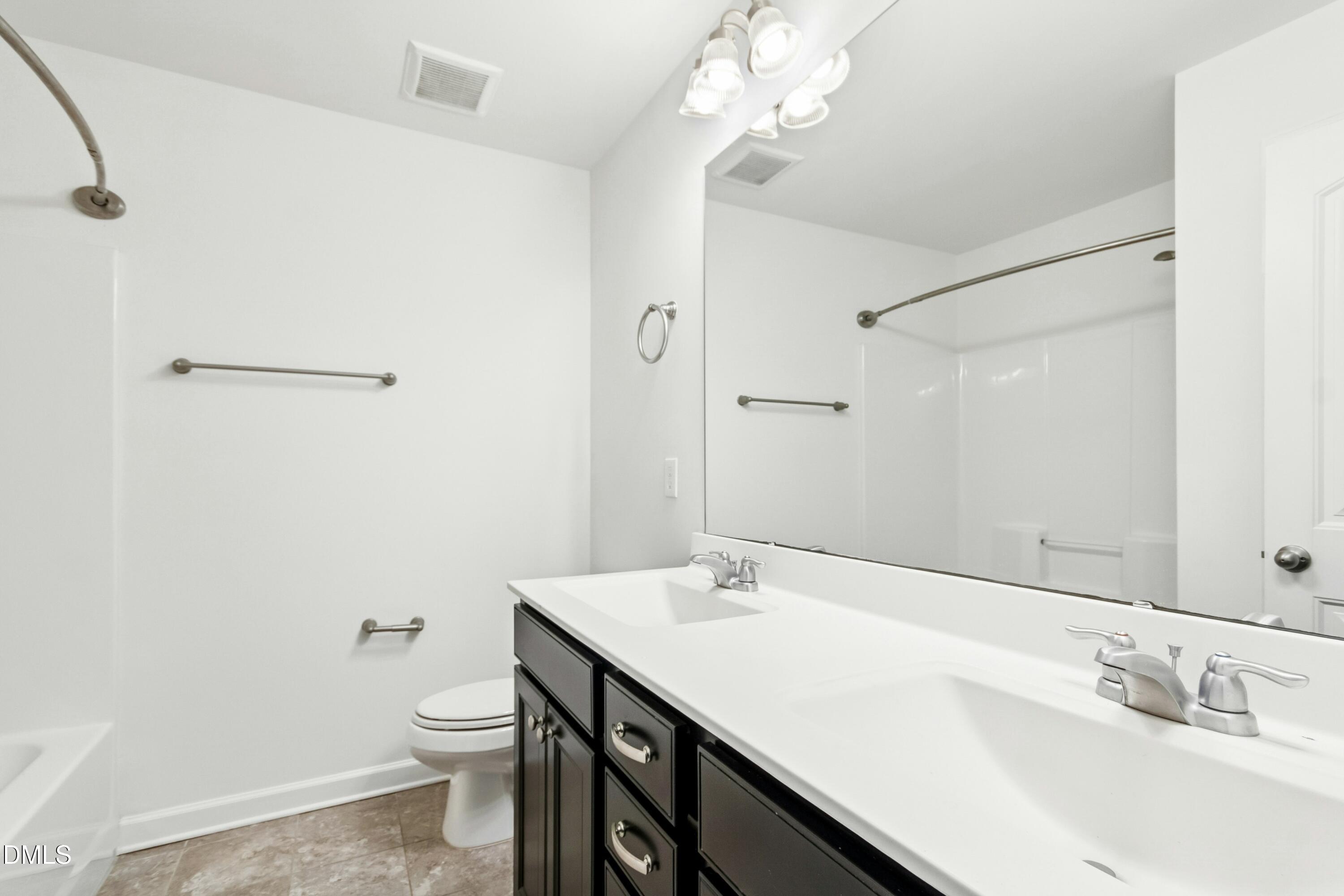 125 Spring Pine Lane Holly Springs, NC 27540 - Photo 26 of 34 a bathroom with a sink a toilet a mirror and shower