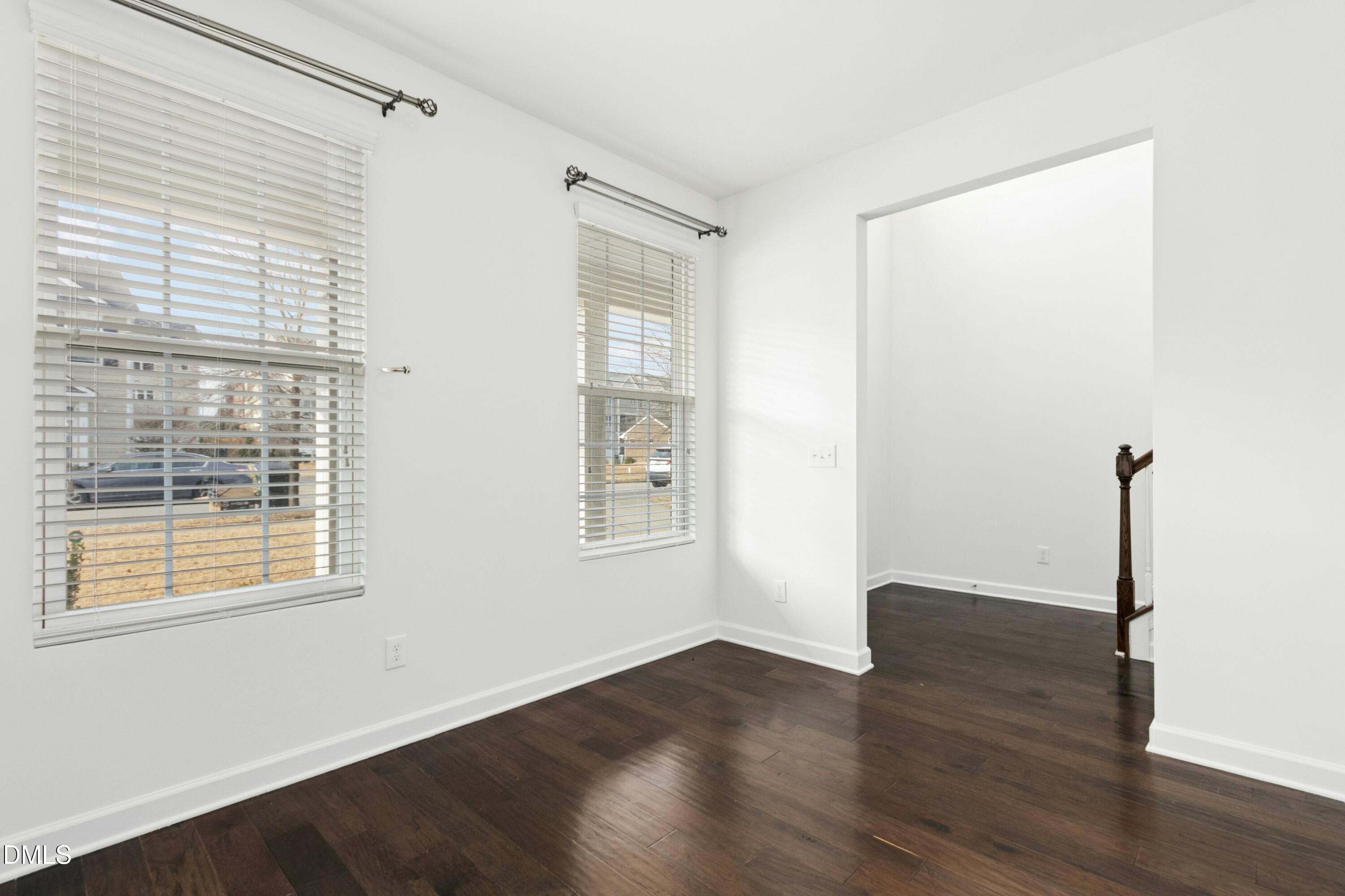 125 Spring Pine Lane Holly Springs, NC 27540 - Photo 4 of 34 a view of an empty room with wooden floor and a window