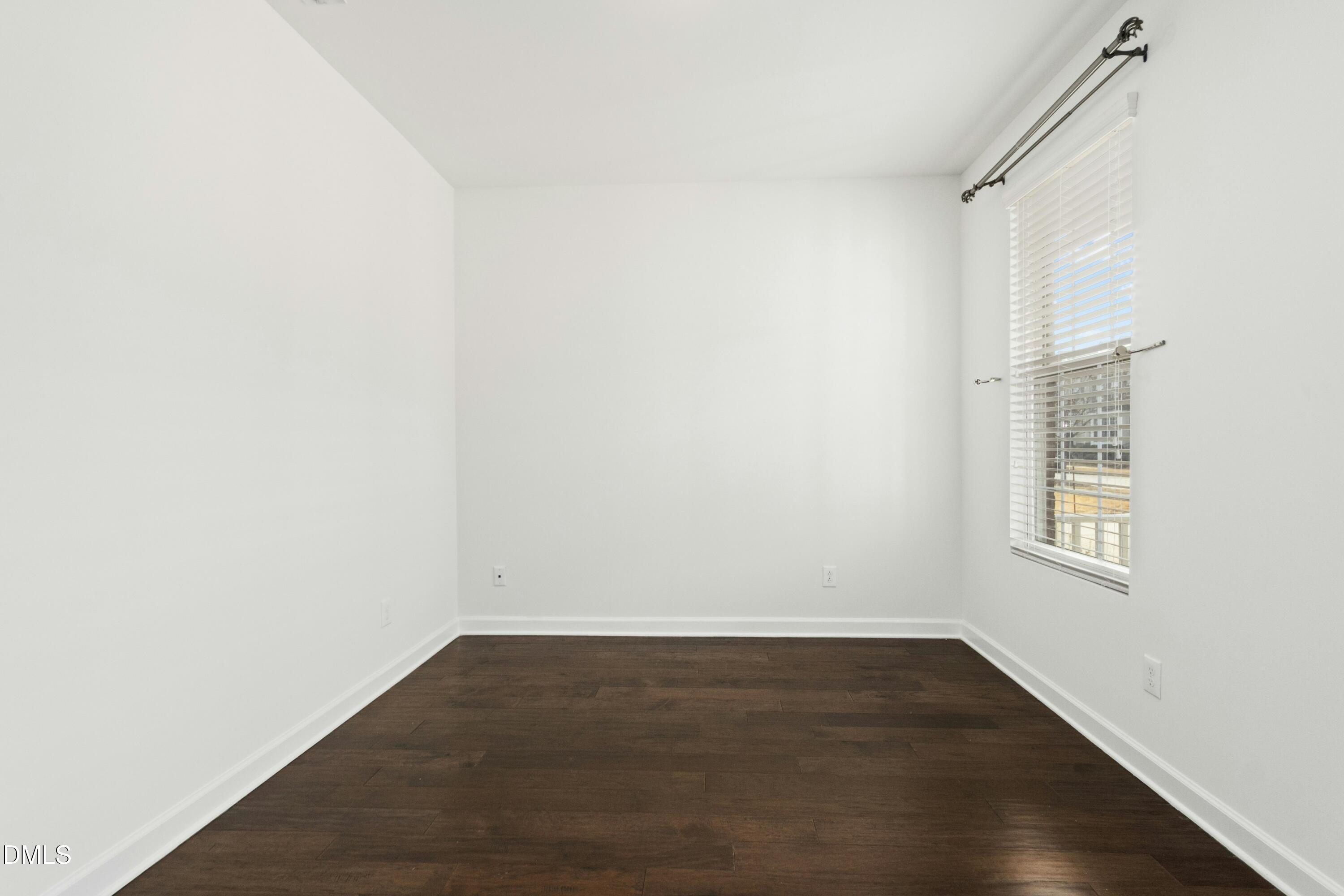 125 Spring Pine Lane Holly Springs, NC 27540 - Photo 5 of 34 an empty room with wooden floor and windows
