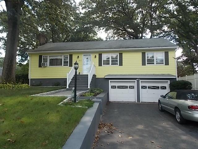 3015 Old Town Road Bridgeport, CT 06606 - Photo 1 of 1 a front view of a house with a garden and trees