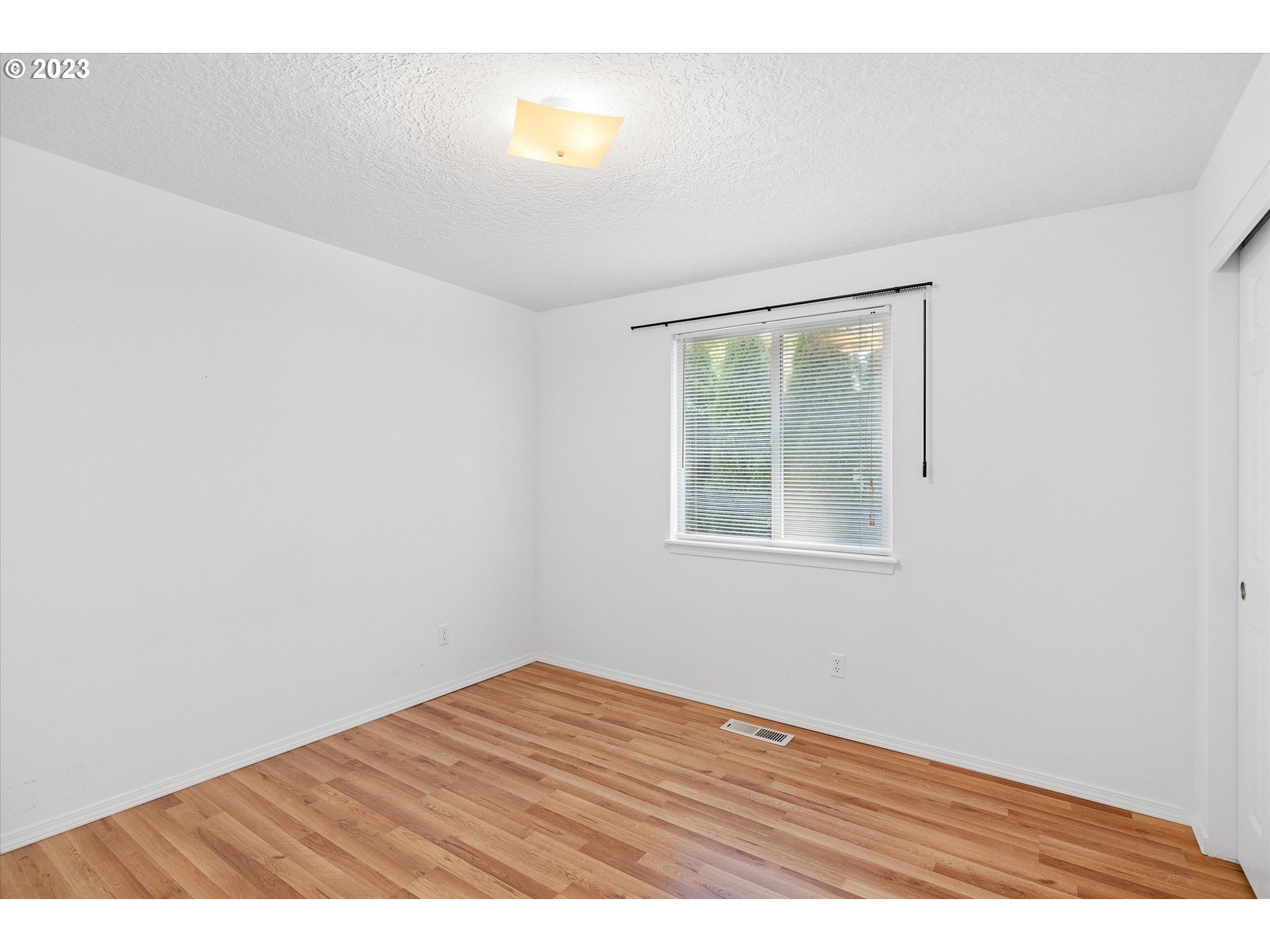 37308 Rachael Drive Sandy, OR 97055 - Photo 16 of 29 an empty room with wooden floor and windows